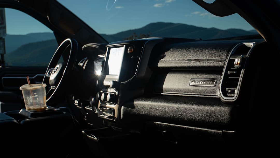 A clipboard and paperwork sitting in the cab of a work truck.